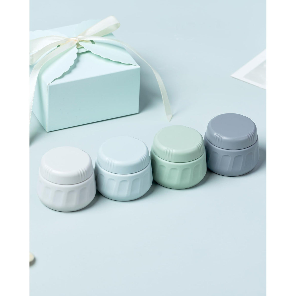Set of four colorful travel containers for toiletries. Available online for easy ordering.