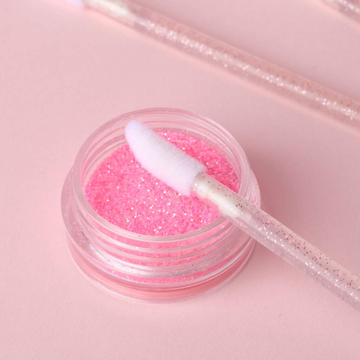 Tbestmax disposable lip brushes with pink glitter in container, perfect for precise lip application and hygiene.
