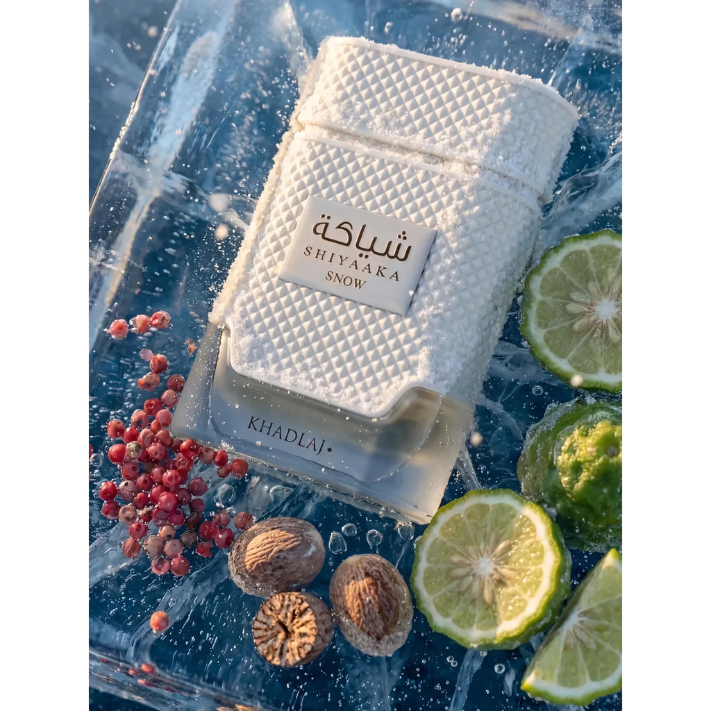 100% Genuine Khadlaj Shiyaaka Snow fragrance featuring a textured bottle surrounded by fresh citrus and spices.