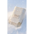 Khadlaj Shiyaaka Snow fragrance bottle nestled in snow, showcasing a luxury design. Verified by CuratCart for authenticity.