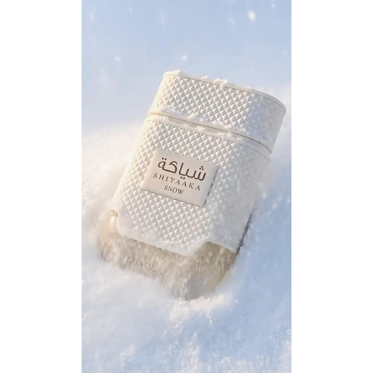 Khadlaj Shiyaaka Snow fragrance bottle nestled in snow, showcasing a luxury design. Verified by CuratCart for authenticity.