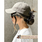 A stylish woman in a baseball cap using a hat-friendly claw clip to secure her hair, ensuring comfort and style. Verified by CuratCart.