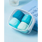 Set of four stylish travel containers in teal and light blue, perfect for organizing toiletries on the go.