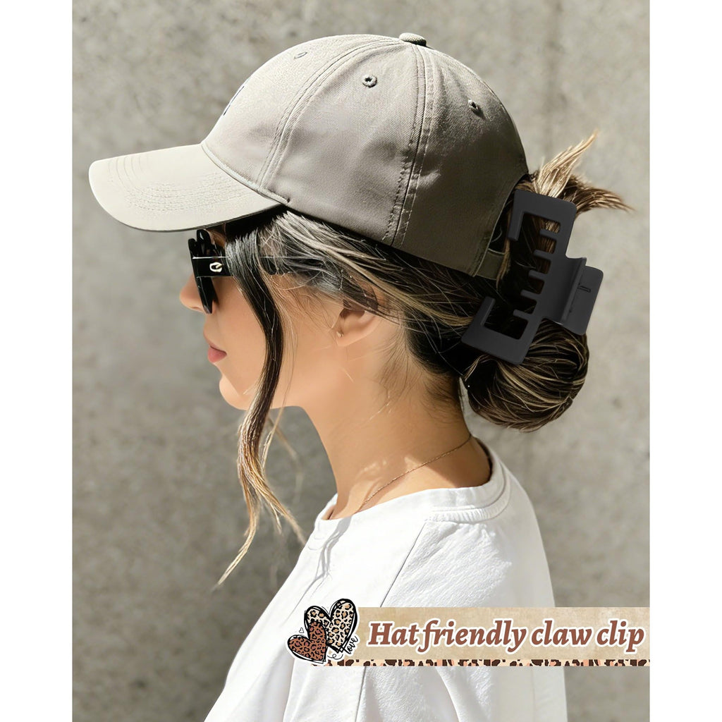 A woman wears a baseball cap and a claw clip, showcasing a perfect solution for stylish hats and convenient hair management.