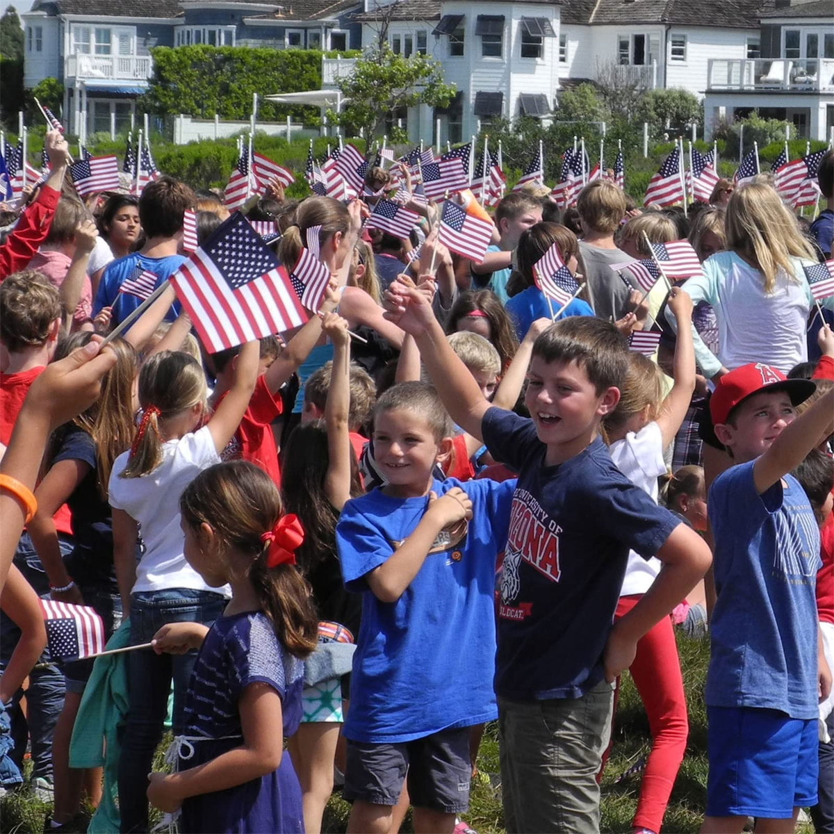 Small American Flags on Stick being enthusiastically waved by children at an outdoor event. 100% Authentic, available at Curat Cart in India.