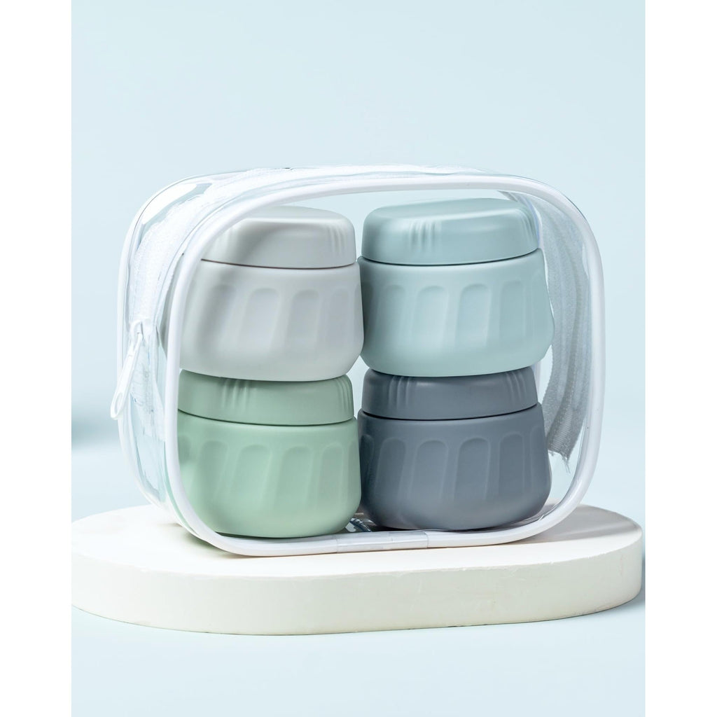 Four stackable travel containers for toiletries in a clear zip bag, ideal for organized packing. Verified by CuratCart.