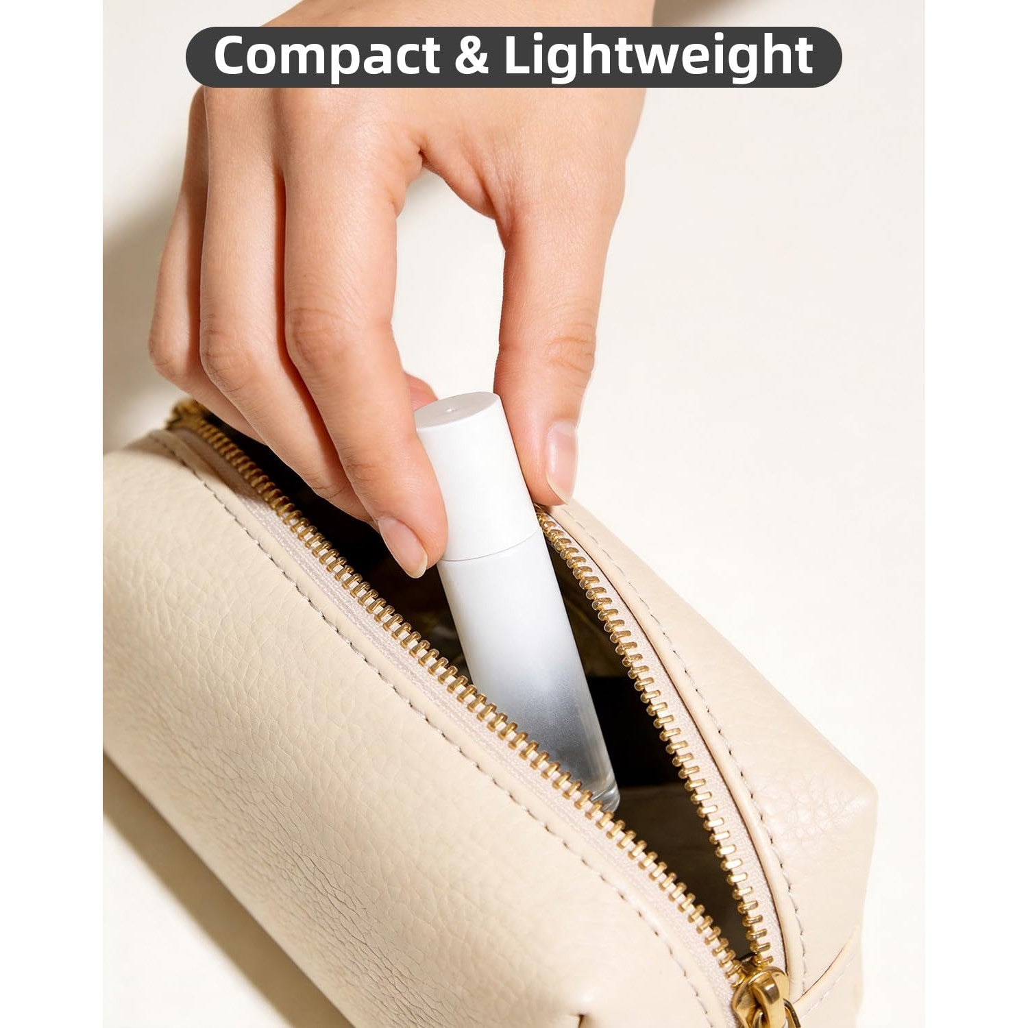 A hand placing a sleek, compact roller bottle into a stylish beige zippered bag, perfect for essential oils.
