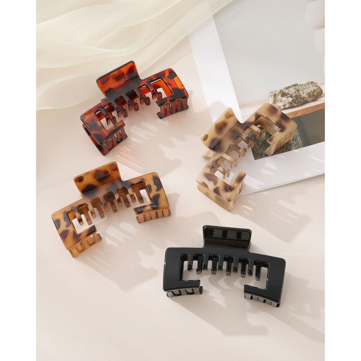 Set of four authentic, stylish claw clips in various patterns, perfect for securely holding baseball caps and hair.