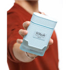 A person holds a stylish Khadlaj Shiyaaka Snow perfume bottle, featuring a unique textured design and a refreshing citrusy, woody scent.