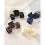 Set of four hat-friendly claw clips in black, navy, brown, and cream. Premium imported for ultimate style and convenience.