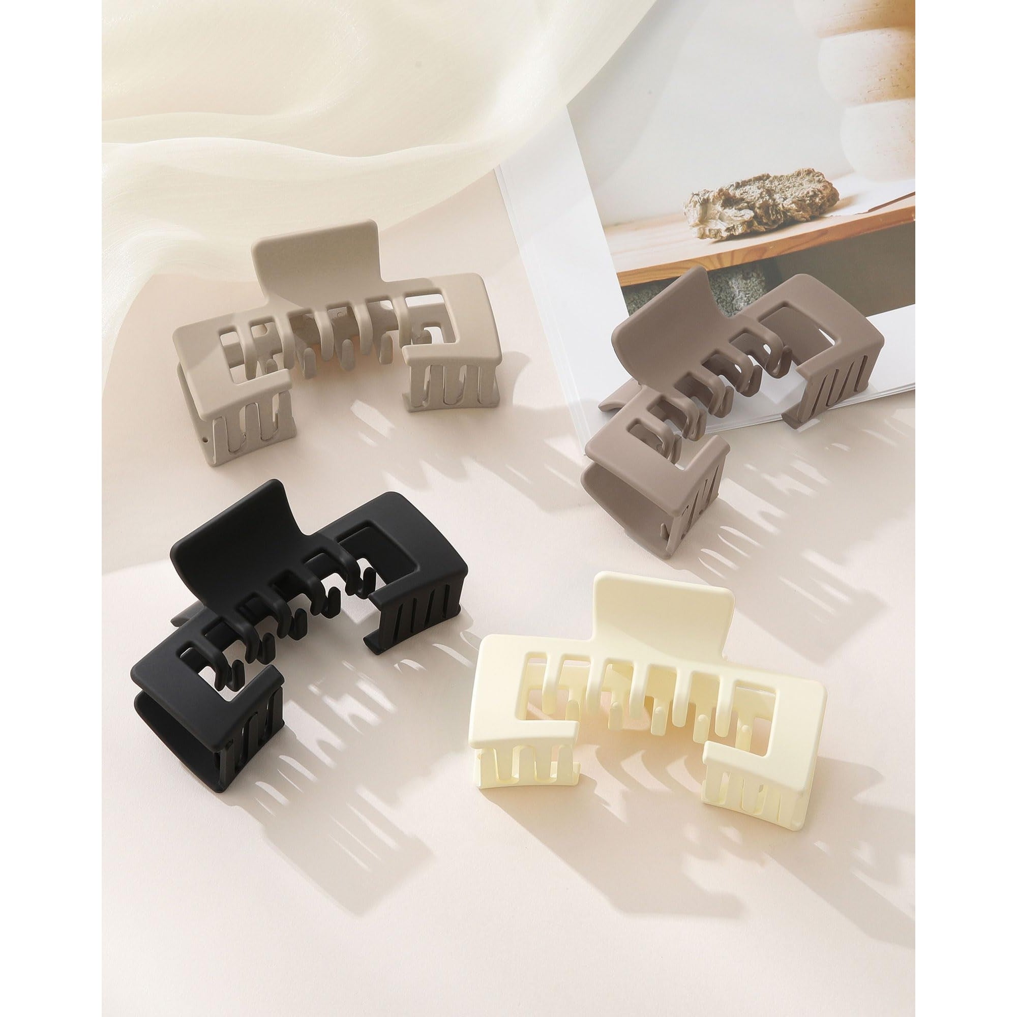 Set of four authentic claw clips, designed for hair convenience while wearing baseball caps, in neutral colors.
