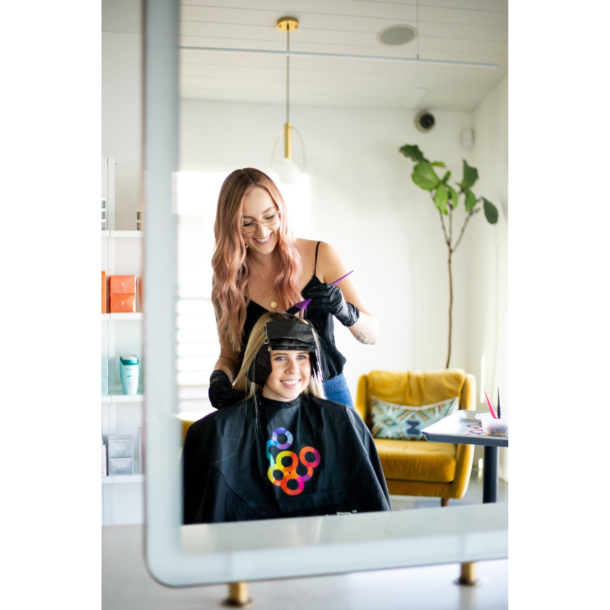 Professional stylist using Framar Family Hair Color Brush Set on client, showcasing authentic hair coloring experience.