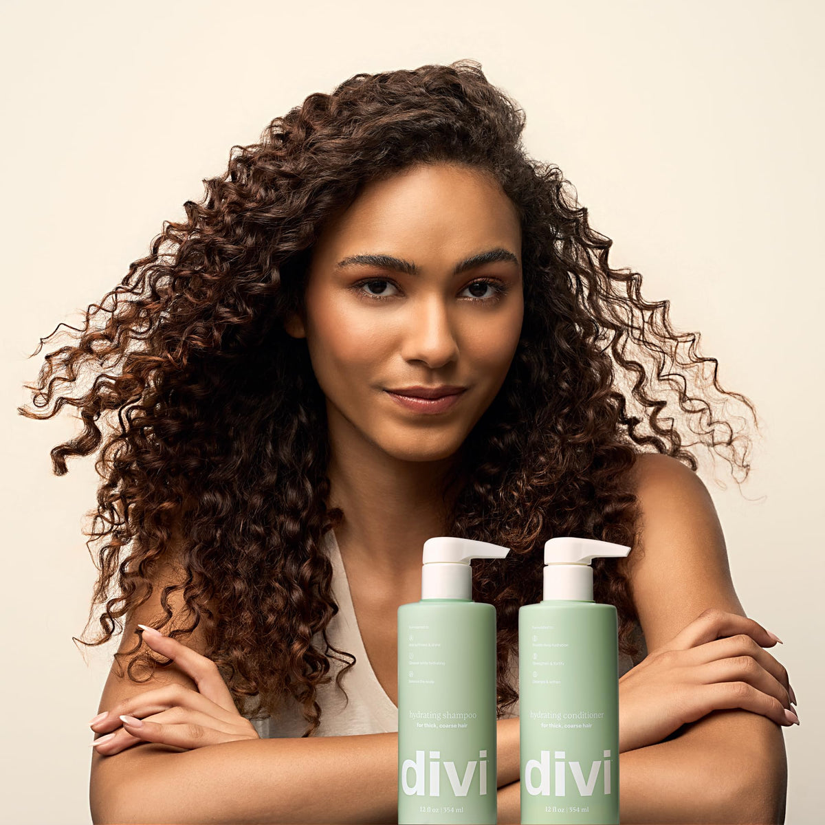 Model showcasing Divi Volumizing Shampoo and Conditioner. Curly hair care products verified by CuratCart for quality.