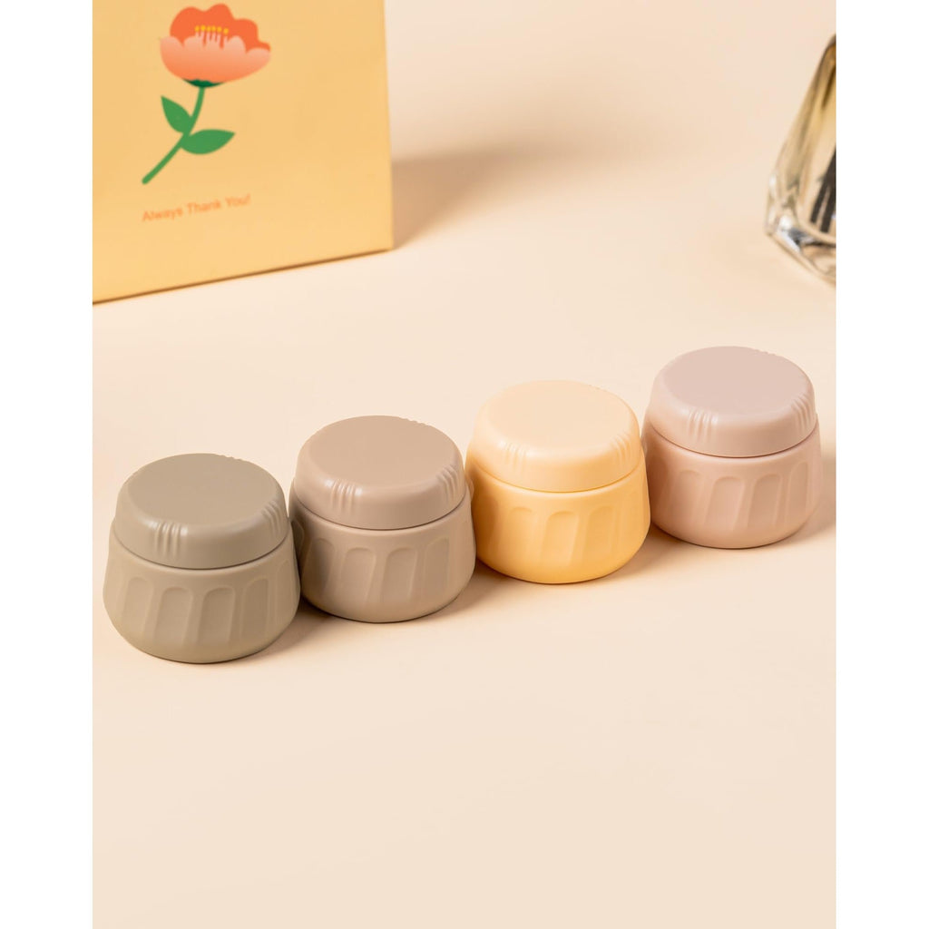 Four stylish pastel travel containers for toiletries, perfect for organized packing and travel convenience.