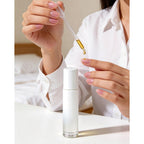 A woman applying essential oil from a dropper into a roller bottle. Order now for 12-pack roller bottles, perfect for oils!