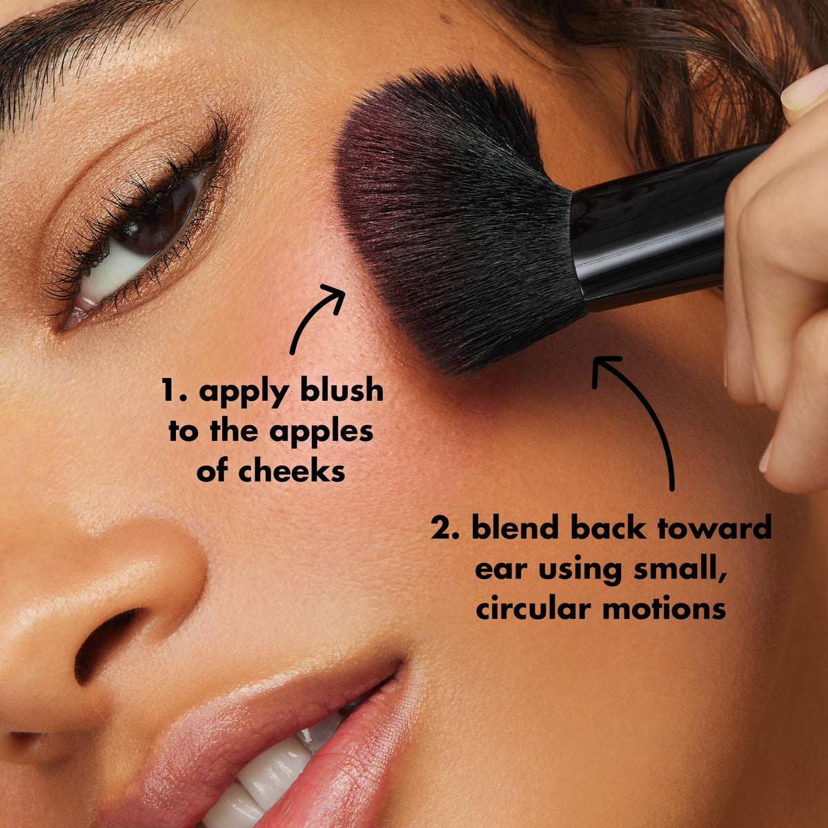 A woman uses the e.l.f. Angled Blush Brush to apply blush on her cheeks. Verified by CuratCart for quality assurance.