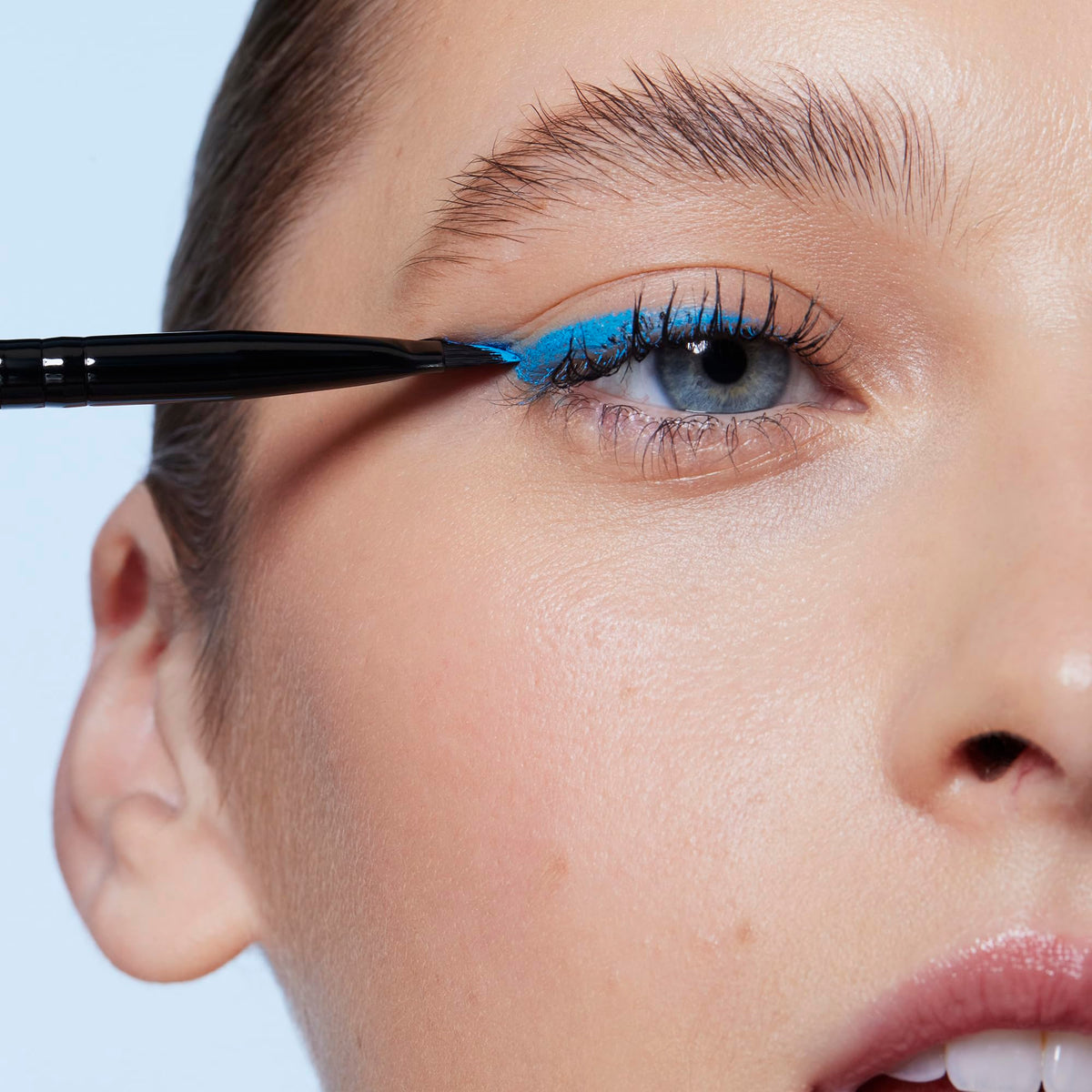 Premium imported e.l.f. Wing It Liner Brush in action, creating a striking blue eyeliner look for bold beauty.