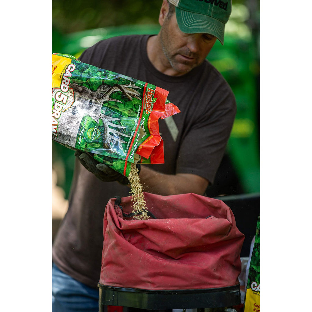 Evolved Harvest Food Plot Seed being poured into a container, ideal for enhancing your garden. Available at Curat Cart.
