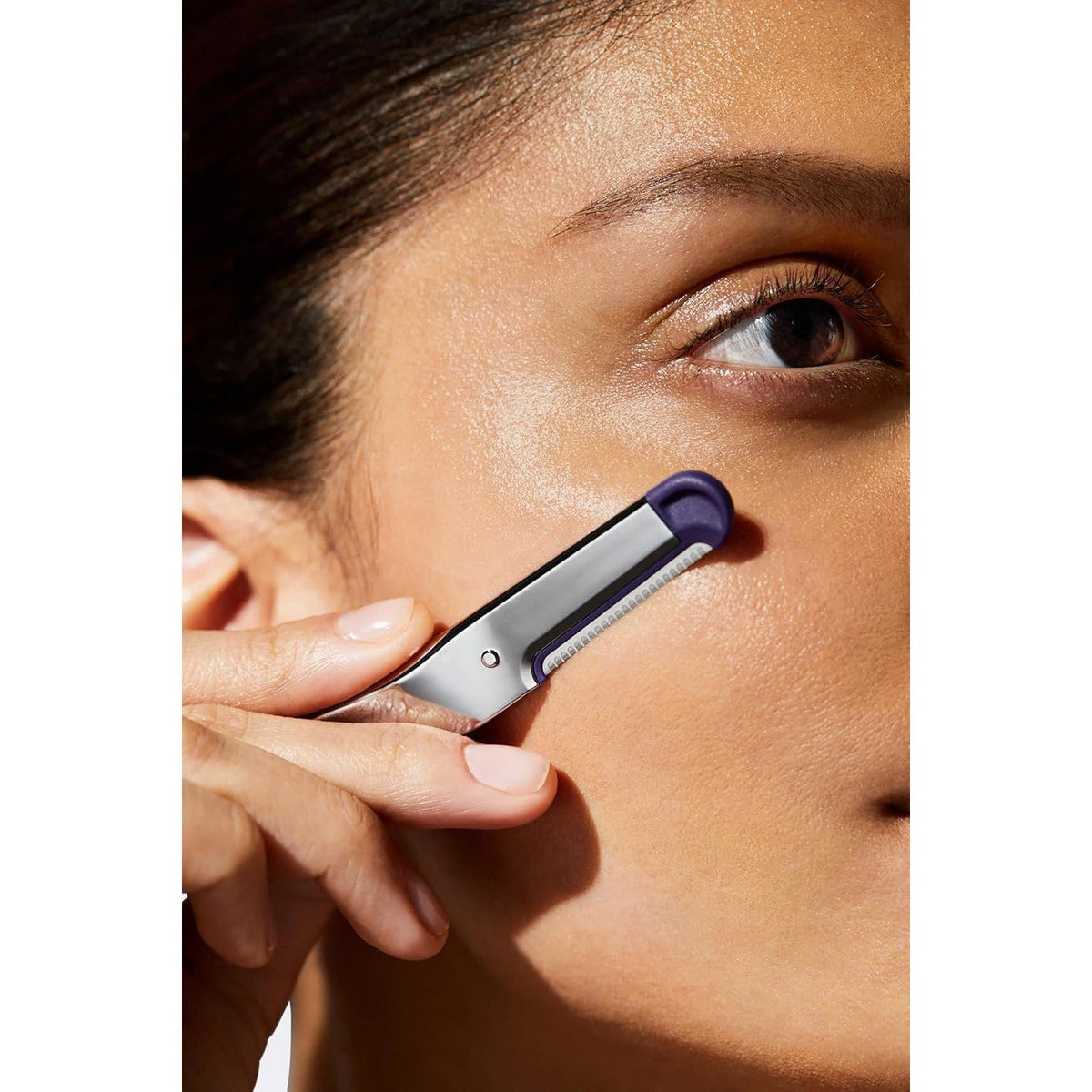 Close-up of a woman using Flamingo dermaplane blade. Available in India, order online for smooth skin.