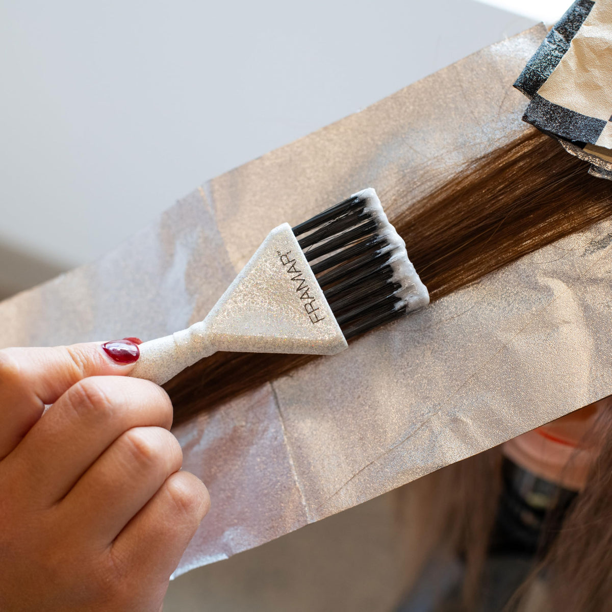 Authentic Framar Family Hair Color Brush Set. User applies dye to hair, ensuring precise application with a sturdy brush.