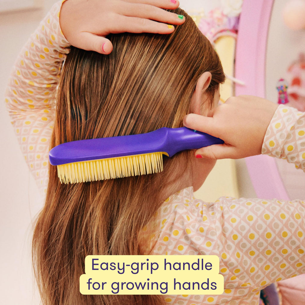 A child using Frida's detangling hair brush with an easy-grip handle, ideal for managing hair with ease.