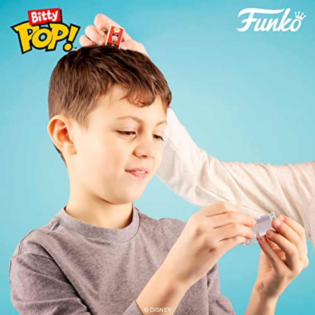 A young boy smiles while holding a Funko Bitty POP! figure. Enjoying a magical Disney collection, verified by CuratCart.