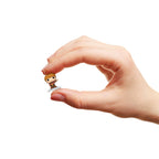A hand holding a small Funko Bitty POP! figure of a BTS member from the Dynamite stage set, showcasing original packaging.