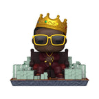 Funko POP! Deluxe figure of The Notorious B.I.G. wearing a crown, sunglasses, surrounded by stacks of money. Available online now.