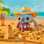 Special Edition Funko POP! Stitch in a tourist outfit, holding a camera on a sandy beach with vibrant colors.