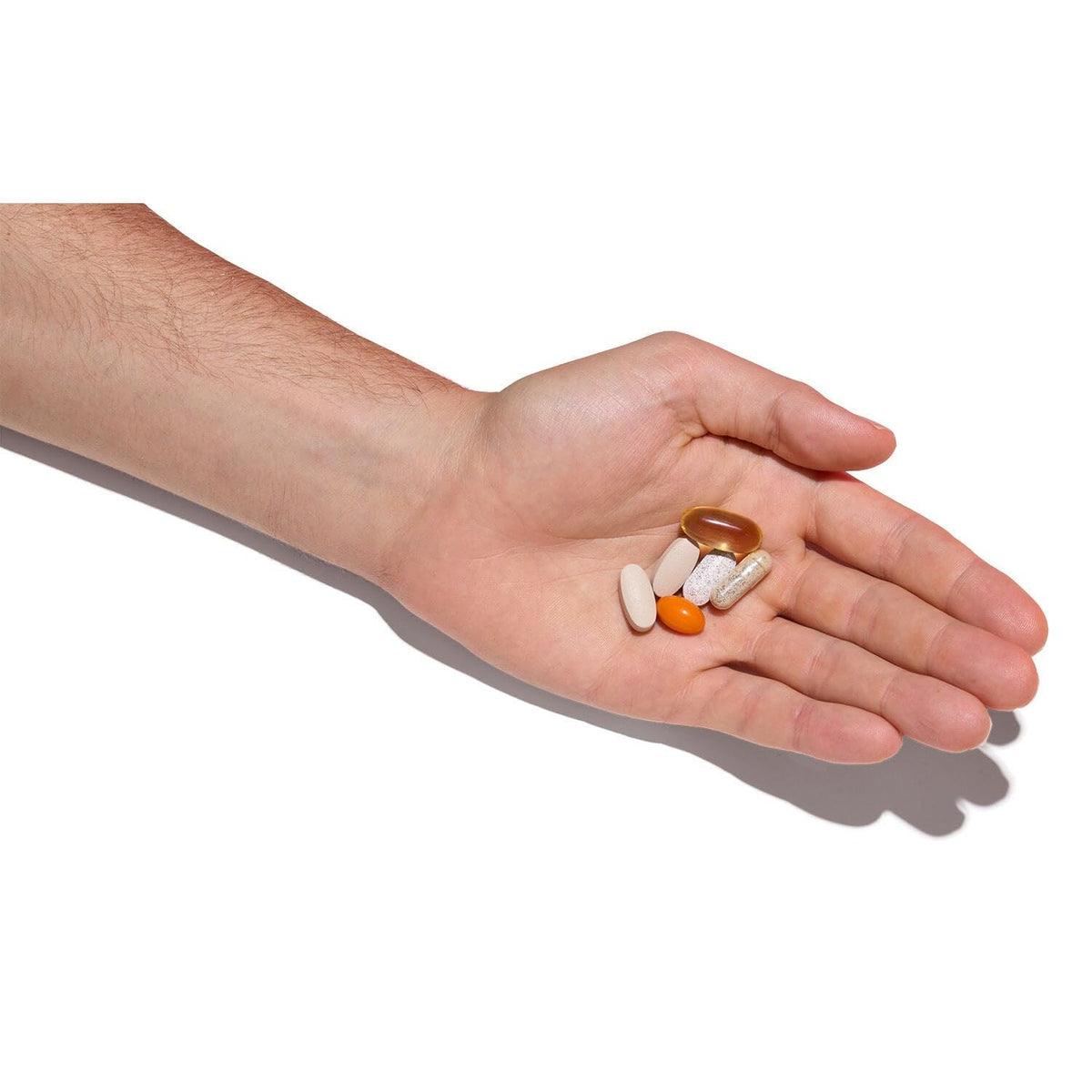 Original GNC Mega Men 50 Plus Vitapak displayed in a hand, showcasing a variety of essential vitamins and minerals.