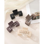 Set of four authentic hat-friendly claw clips in black, brown, beige, and light tan, perfect for styling with baseball caps.