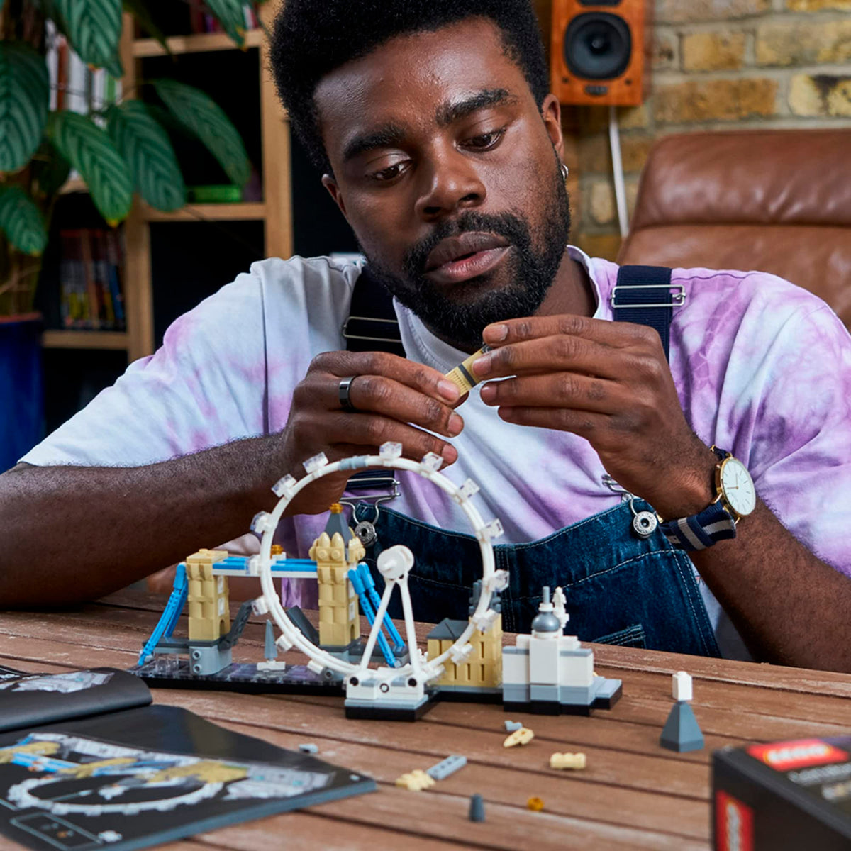 A man builds the LEGO Architecture London Skyline set, showcasing iconic landmarks. Order online, available in India.
