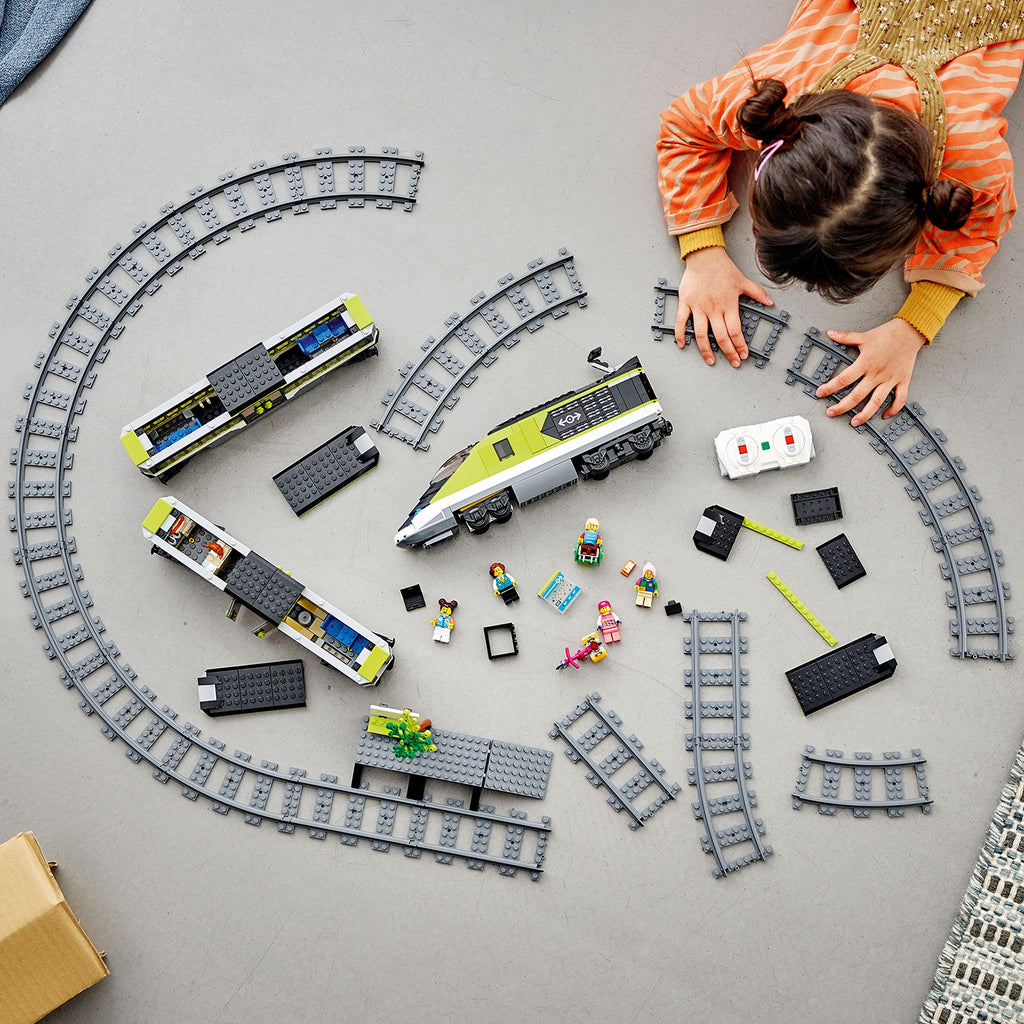Colorful LEGO City Express Passenger Train set with tracks, accessories, and kids assembling pieces. Original packaging included.