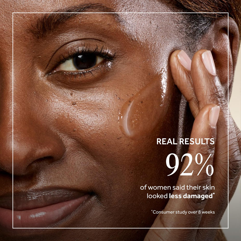 Close-up of a woman applying No7 Future Renew Damage Reversal Anti-Aging serum, showcasing radiant skin results.