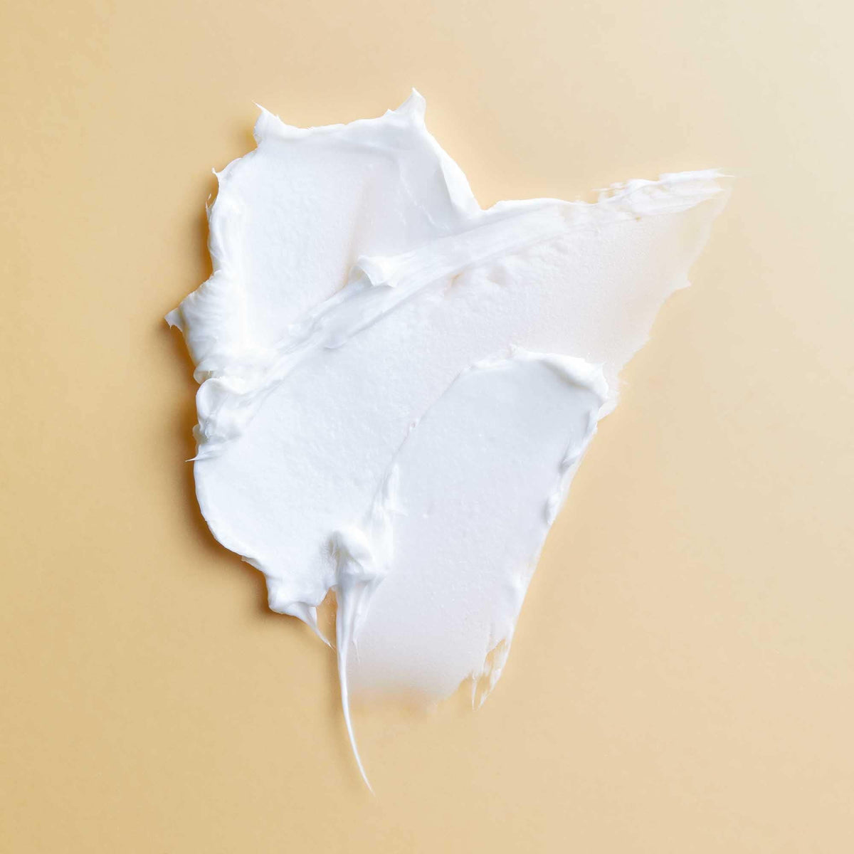 A creamy, white swatch of PATTERN Beauty by Tracee Ellis Ross Mini hair product highlighting its smooth, rich texture.