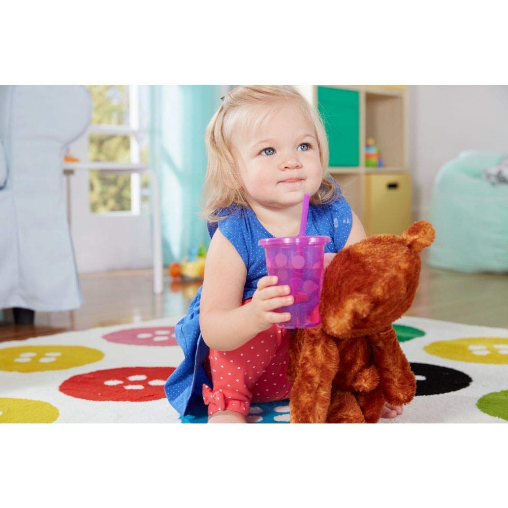 A toddler enjoys a vibrant pink straw cup while cuddling a plush toy, showcasing The First Years Straw Cup's playful design.