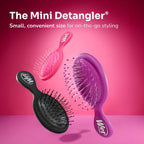 Three Wet Brush Mini Detangler Hair Brushes in pink, purple, and black against a vibrant pink background for on-the-go styling.