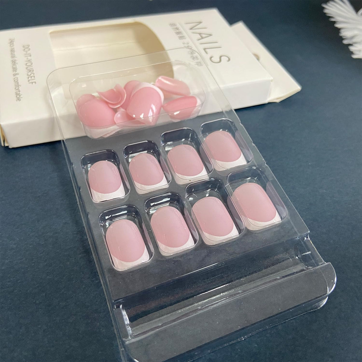 Set of short square press-on nails with white French tips, featuring a soft pink base. Verified by CuratCart for quality assurance.